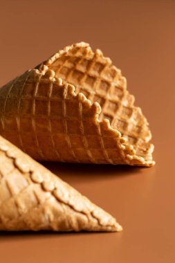 Waffle cones on brown background, texture ice cream cones, creative macro concept.