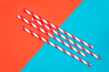 Drinking straws for party on colored background. Top view of colorful paper disposable eco-friendly straws for summer cocktails.