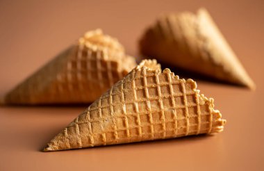 Waffle cones on brown background, texture ice cream cones, creative macro concept.