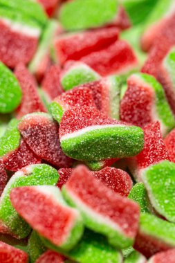 Texture background with watermelon shaped jelly candies, macro shot.