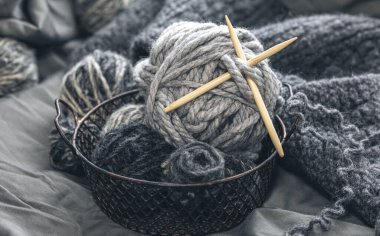 Close-up, gray threads for knitting, yarn with wooden knitting needles.