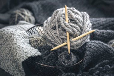 Close-up, gray threads for knitting, yarn with wooden knitting needles.