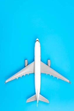 White plane, airplane on a blue background with copy space. Top view, flat lay. Minimal style design. Travel, vacation concept.