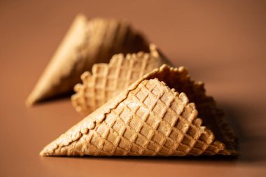 Waffle cones on brown background, texture ice cream cones, creative macro concept.