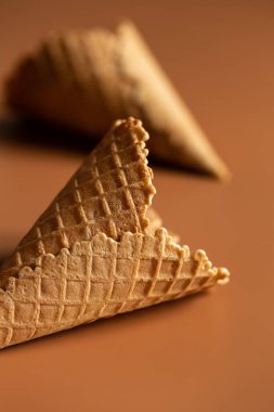 Waffle cones on brown background, texture ice cream cones, creative macro concept.
