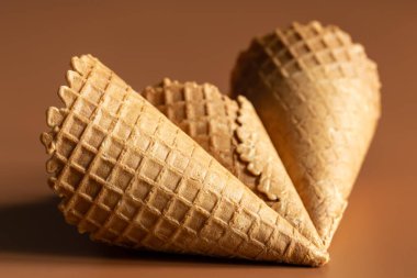 Waffle cones on brown background, texture ice cream cones, creative macro concept.