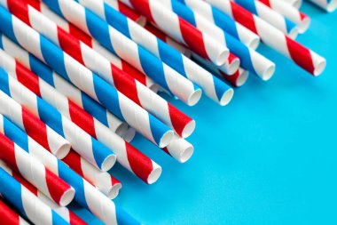 Drinking straws for party on blue background, colorful paper disposable eco-friendly straws for summer cocktails.