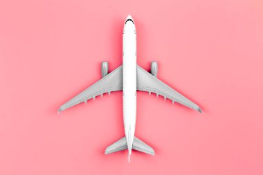 Airplane on a pink background, flat lay, travel concept, close up.