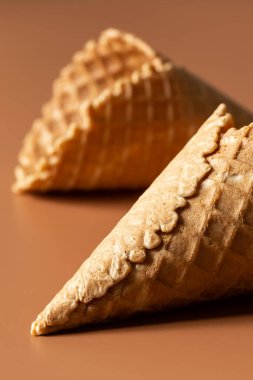 Waffle cones on brown background, texture ice cream cones, creative macro concept.