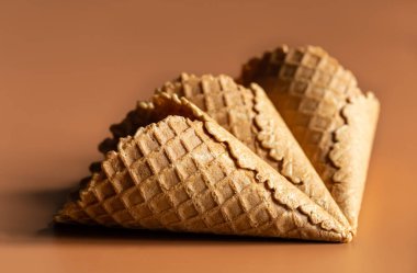 Waffle cones on brown background, texture ice cream cones, creative macro concept.