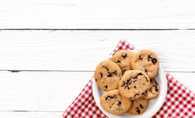 Chocolate chip cookies on a wooden background, flat lay, copy space.