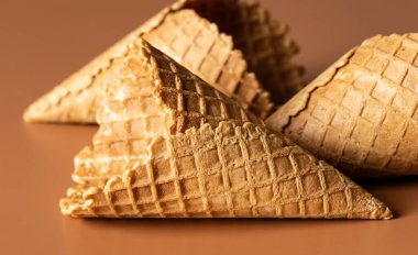 Waffle cones on brown background, texture ice cream cones, creative macro concept.