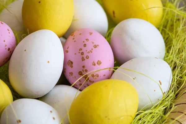 Easter dessert for children, egg-shaped candies in a decorative nest, close up.