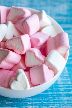 Bowl with pink and white marshmallows in the form of hearts, close-up.