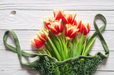 Bouquet of tulips on a white wooden background, top view, close up, rustic style.