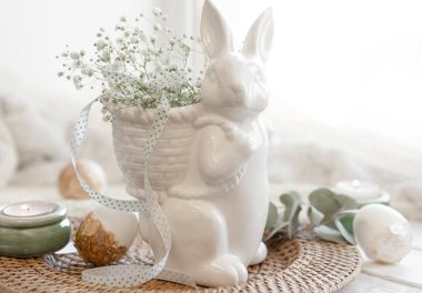 Seramik tavşan, yumurta ve çigila çiçekli hafif Paskalya kompozisyonu.