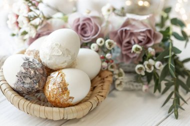 Festive Easter composition with stylish decorative eggs and flowers, close-up.