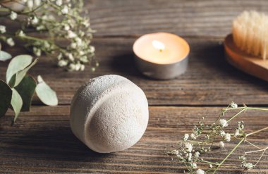 Banyo bombası, mum ve kurumuş çiçeklerle kaplıca kompozisyonu ahşap yüzeyde, köy tarzı..