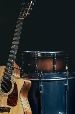Akustik gitar ve davul siyah zemin izole edilmiş, müzik konsepti.
