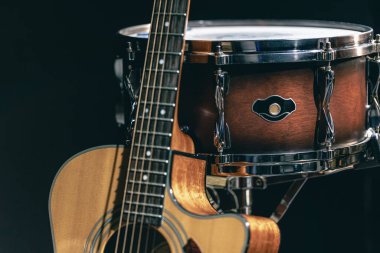 Akustik gitar ve davul siyah zemin izole edilmiş, müzik konsepti.