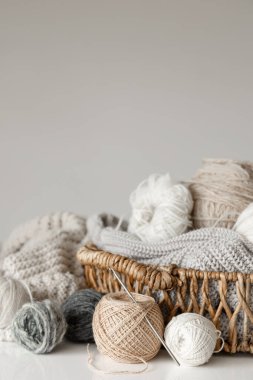 İpliği yakın çekimli sepet, bulanık beyaz arkaplanda örgü örmek için pastel renk iplikleri.