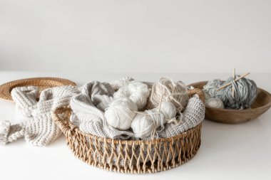 İpliği yakın çekimli sepet, bulanık beyaz arkaplanda örgü örmek için pastel renk iplikleri.