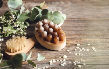 Masaj sabunu ve ahşap bir arka planda kurutulmuş çiçeklerle fırçalanmış spa kompozisyonu, kopyalama alanı.