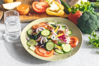 Fresh vegetable salad on the kitchen table in a plate close-up, the concept of healthy eating, weight loss and diet.