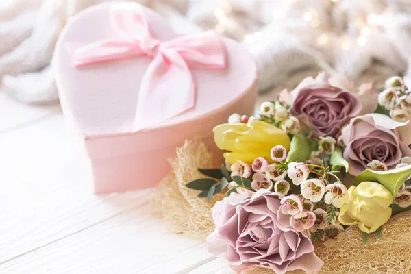 Spring composition with flowers and gift box on blurred background, concept of Mothers day, Womens day.