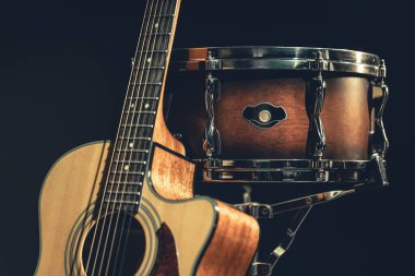 Akustik gitar ve davul siyah zemin izole edilmiş, müzik konsepti.