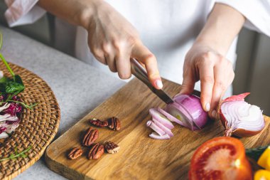 A woman making fresh vegetable salad, close-up, concept of diet and healthy eating.