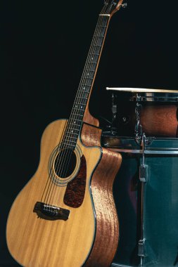 Akustik gitar ve davul siyah zemin izole edilmiş, müzik konsepti.