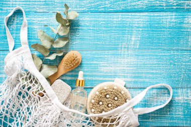 Vücut bakımı için kişisel hijyen malzemelerini içeren spa kompozisyonu mavi ahşap bir arka planda, üst görünümde, kopyalama alanı.