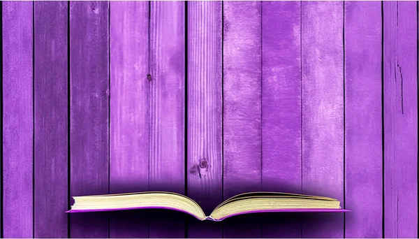 Open book on purple wooden background, flat lay.
