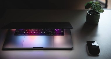 Geceleri çalışan bir dizüstü bilgisayarın klavyesini renkli bir şekilde kapat. Birden fazla renk arkaplanı olan bir ekran görüntüsünün aydınlatılmasıyla birlikte...