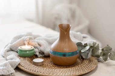 Bulanık arka planda aroma yağı yayıcı lambasıyla sıcacık spa kompozisyonu.