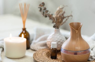 Bulanık arka planda aroma yağı yayıcı lambasıyla sıcacık spa kompozisyonu.