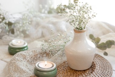 Bulanık bir arka planda, alçı çiçekleri ve mumlarla bahar kompozisyonu, boşluğu kopyala.