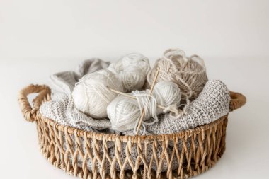 İpliği yakın çekimli sepet, bulanık beyaz arkaplanda örgü örmek için pastel renk iplikleri.