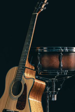 Akustik gitar ve davul siyah zemin izole edilmiş, müzik konsepti.