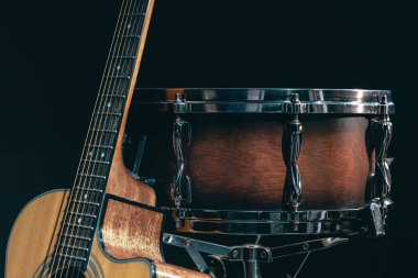 Akustik gitar ve davul siyah zemin izole edilmiş, müzik konsepti.