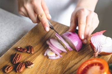 A woman making fresh vegetable salad, close-up, concept of diet and healthy eating.