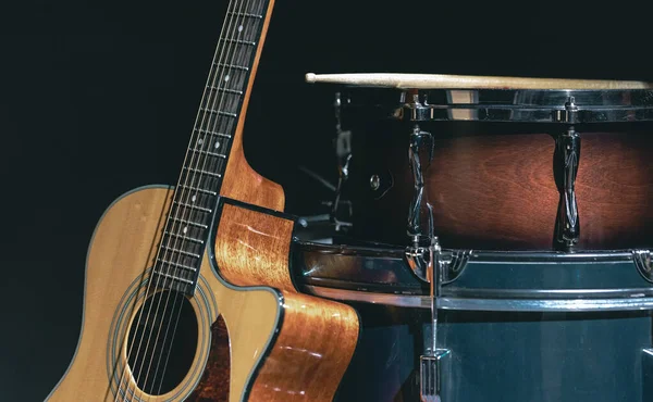 Akustik gitar ve davul siyah zemin izole edilmiş, müzik konsepti.
