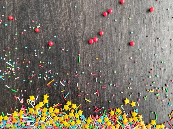 stock image Multicolored baking powder sprinkled on a wooden table, top view.