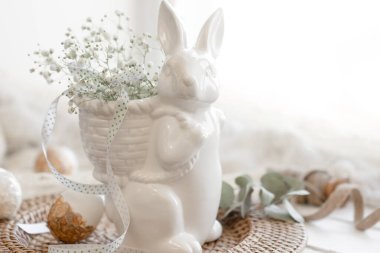 Seramik tavşan, yumurta ve çigila çiçekli hafif Paskalya kompozisyonu.