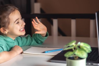 Bilgisayarın önündeki komik küçük kız, online çalışma konsepti, ev okulu..