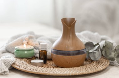 Bulanık arka planda aroma yağı yayıcı lambasıyla sıcacık spa kompozisyonu.