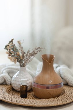 Bulanık arka planda aroma yağı yayıcı lambasıyla sıcacık spa kompozisyonu.