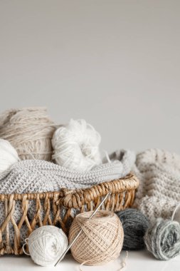 İpliği yakın çekimli sepet, bulanık beyaz arkaplanda örgü örmek için pastel renk iplikleri.