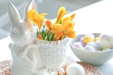 Paskalya 'da seramik tavşan, dekoratif yumurta ve ilk bahar çiçekleri.